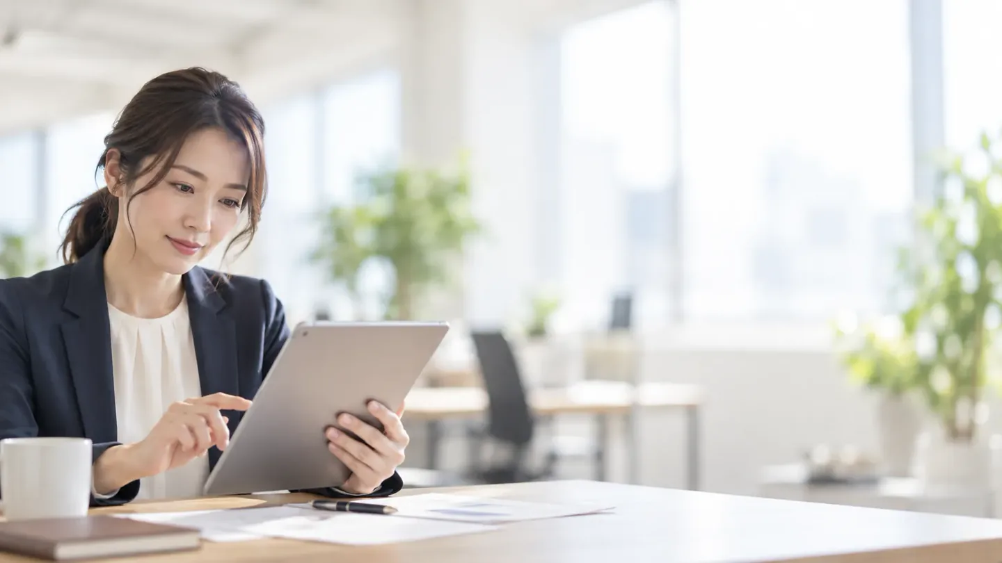 事務所の机で、タブレットの内容を確かめている人